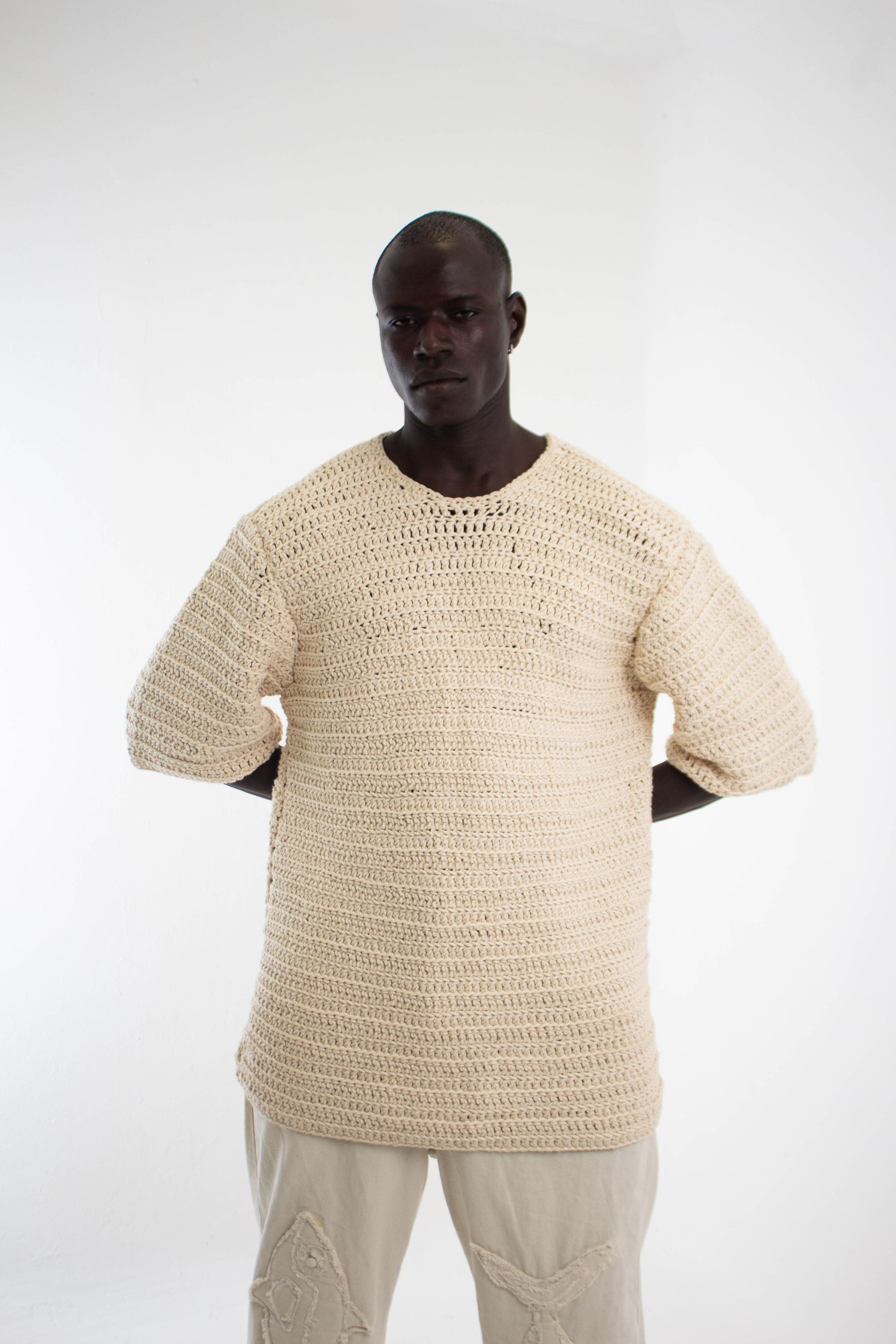 Model wearing ARRA cream open-knit top